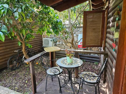 a patio with two chairs and a table and a bike at Zimmer In The Garden in Karmiel