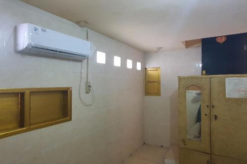 ein Bad mit einer Klimaanlage an der Wand in der Unterkunft OYO 93895 Koh Wat Homestay Syariah in Plosobegem