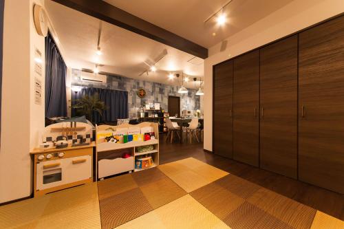 a room with a kitchen with a counter and a table at ガジュマルの庭～itoman in Ō