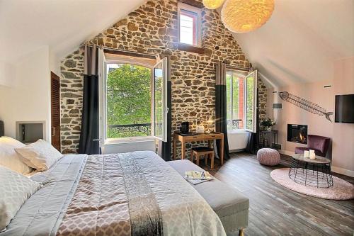 1 dormitorio con 1 cama grande y pared de piedra en Villa De Alexiano, en Alixan