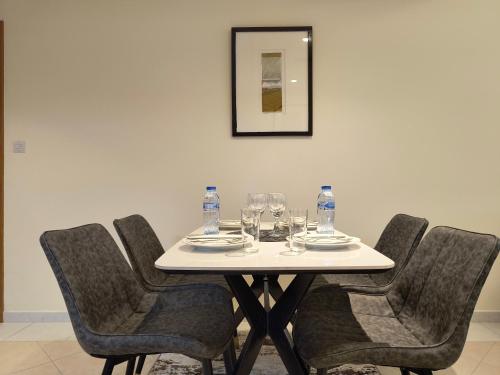 a table with chairs and wine glasses on it at Trinity Holiday Homes - Sheikh Zayed Road Near to Financial Center Metro Station in Dubai