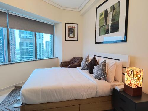 a bedroom with a large bed and a window at Trinity Holiday Homes - Sheikh Zayed Road Near to Financial Center Metro Station in Dubai