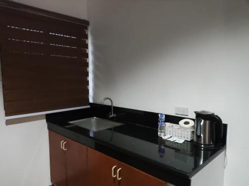 a kitchen with a sink and a counter top at Balai Subik Hotel in Olongapo