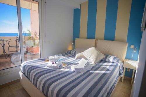 une chambre avec un lit à rayures bleues et blanches dans l'établissement Eden Palace 9 Attico - Happy Rentals, à Menton