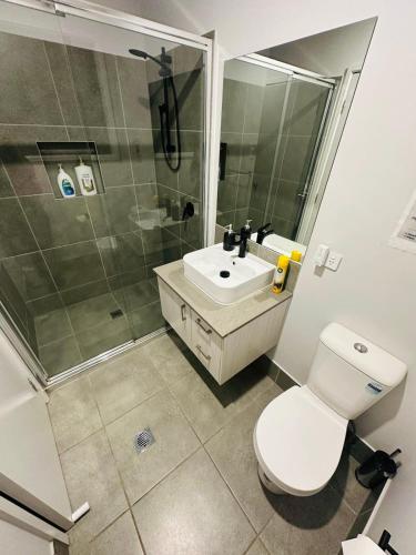 a bathroom with a toilet and a sink and a shower at A Private Ensuite with AC and TV in Austral