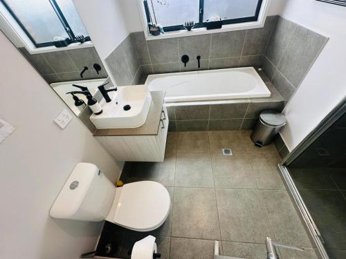 La salle de bains est pourvue d'une baignoire, de toilettes et d'un lavabo. dans l'établissement A Private Ensuite with AC and TV, à Austral
