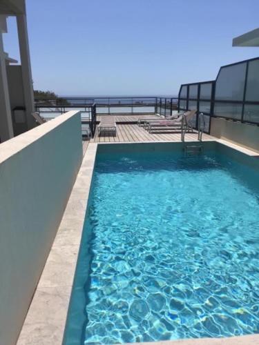 - une piscine au-dessus d'un bâtiment donnant sur l'océan dans l'établissement Charmant F3 vue mer avec piscine, à Bandol