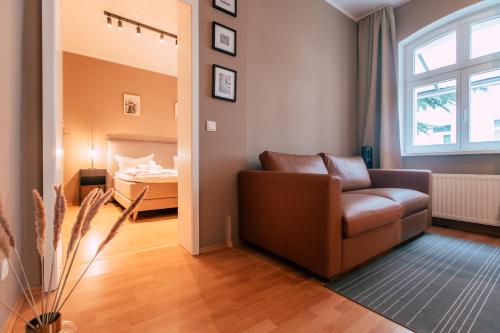 a living room with a couch and a bed at Luga Homes - Chausseehaus in Leipzig