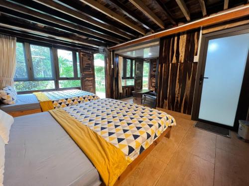 a bedroom with two beds and a large window at SEN VILLA Boutique in Bao Loc