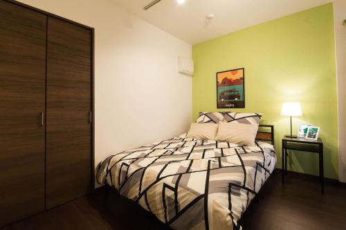 a bedroom with a bed in a room with green walls at ガジュマルの庭～itoman in Ō