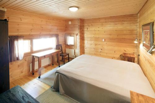 een slaapkamer met een bed in een houten kamer bij Okkolan Lomamökit in Puumala