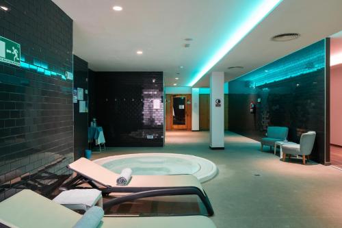 un gran cuarto de baño con jacuzzi y sillas en O7 Aloe Corralejo en Corralejo