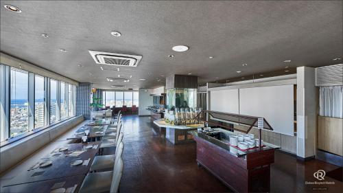a restaurant with tables and a view of the city at Daiwa Roynet Hotel Naha Omoromachi in Naha