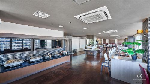 那覇市にあるダイワロイネットホテル那覇おもろまちのテーブルと椅子が備わる待合室のあるレストラン