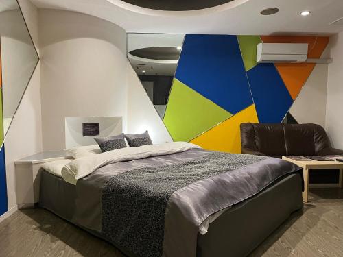 Kanie的住宿－HOTELウォーターゲート蟹江（カップル専用），一间卧室配有一张带彩色墙壁的床