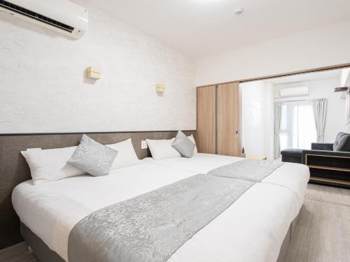 a large white bed in a room with a window at Dream Inn Hakata in Fukuoka