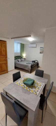 mesa de comedor y sillas en una habitación con cama en Appartamento Limone, en Cala Gonone