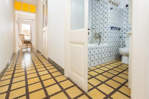 baño con suelo de baldosa de color amarillo y azul en Ca L' Anton, en Palafrugell
