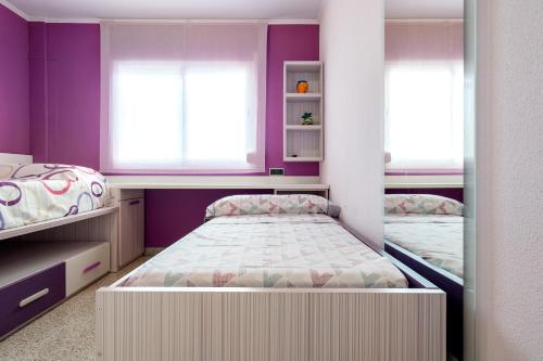 a bedroom with two beds and purple walls at Casa García in L'Aldea