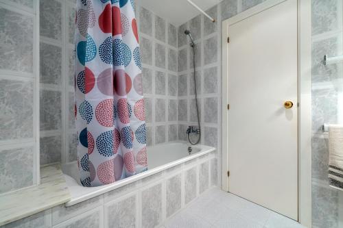 een badkamer met een douchegordijn en een bad bij Casa García in L'Aldea