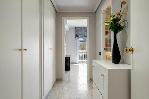 a hallway with white cabinets and a vase of flowers at Casa García in L'Aldea