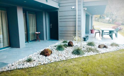 un jardin avec des rochers et des plantes devant une maison dans l'établissement Casa vacanze il bibbiere, à Olgiate Comasco