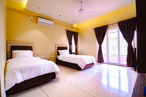 a bedroom with two beds and a window at IND57 in Siliguri