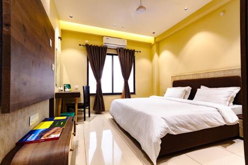 a bedroom with a bed and a desk in it at IND57 in Siliguri