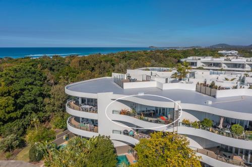 Vue aérienne d'un bâtiment avec l'océan en arrière-plan dans l'établissement Casuarina Resort Style 3BR Apartment by uHoliday, à Casuarina