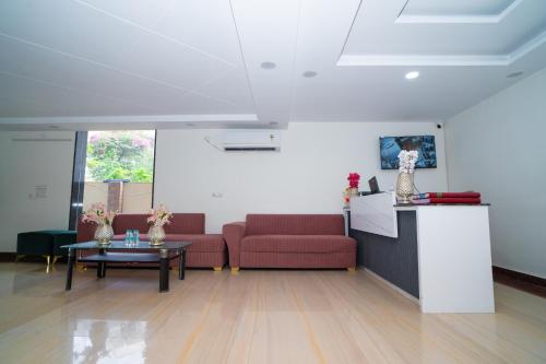 una sala de estar con 2 sofás rojos y una mesa. en Aster Studio Sec-39 Gurgaon I Fully furnished 2BHK, en Gurgaon