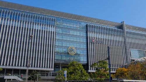 a large glass building with a clock on it at Toyoko Inn Hakata-eki Bus Terminal Mae in Fukuoka
