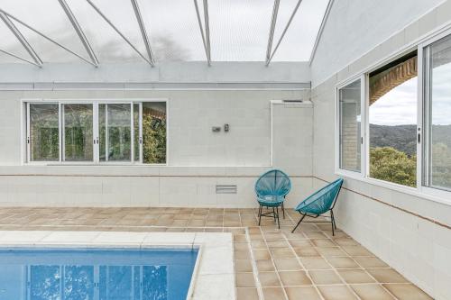 a house with a swimming pool and a blue chair at Casa Nadia in Romanyá de la Selva