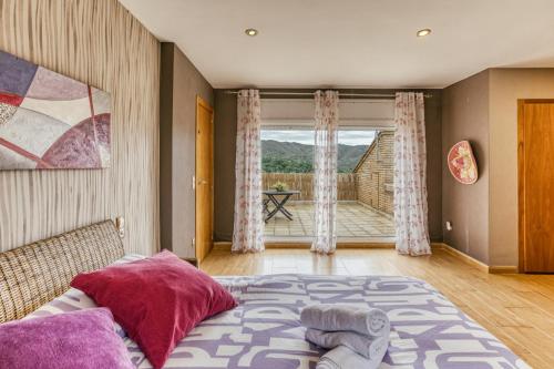 a bedroom with a bed and a large window at Casa Nadia in Romanyá de la Selva
