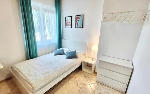 a small bedroom with a bed and a window at Fregata in Łeba