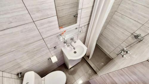 a bathroom with a white sink and a toilet at Fregata in Łeba