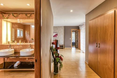 baño con 2 lavabos y espejo grande en Casa Nadia, en Romanyà de la Selva