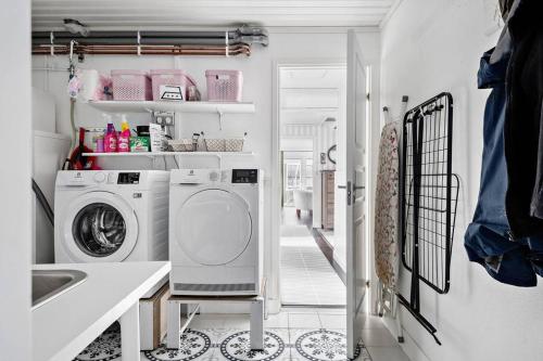 a laundry room with a washing machine and a sink at Nice Villa near Lake! Free boat, sauna and big garden! in Åryd