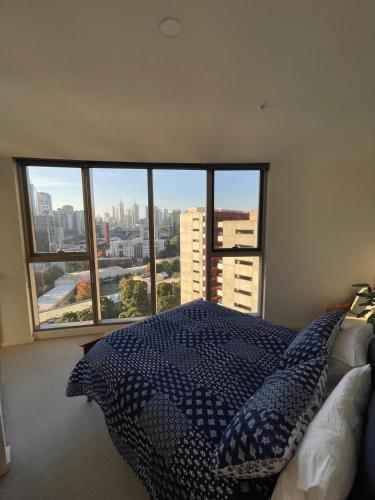 a bedroom with a bed and a large window at Perfect City View and gorgeous apartment in Melbourne