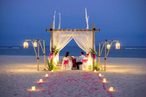 a wedding ceremony on the beach at night at Ayodya Resort Bali in Nusa Dua