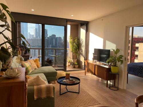 a living room with a couch and a tv at Perfect City View and gorgeous apartment in Melbourne