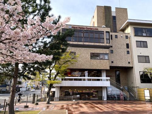 奈良市にある奈良県外国人観光客交流館 (奈良県猿沢イン)のピンクの花の木が目の前に咲く建物