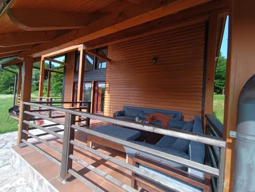 a porch of a house with a blue couch on it at Vikendica Jezerac in Banja Luka