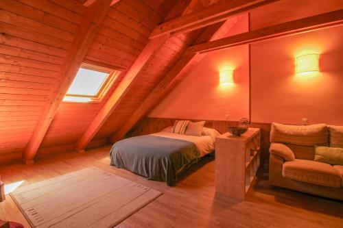 ein Schlafzimmer mit einem Bett und einem Stuhl auf einem Dachboden in der Unterkunft Villa Nuria in Tramacastilla de Tena