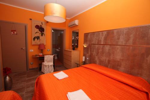 sypialnia z pomarańczowymi ścianami i łóżkiem z pomarańczową pościelą w obiekcie Roma Gianicolense w Rzymie