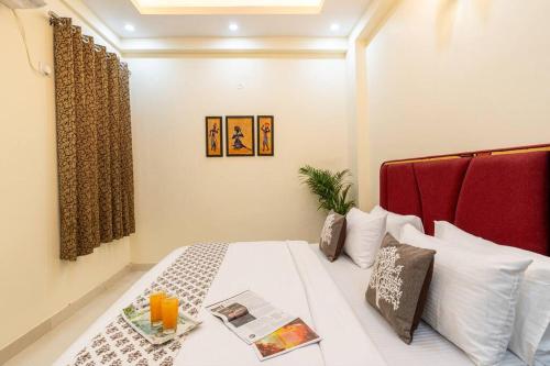 a bedroom with a white bed with a red headboard at Homlee-Vasundhara 2BHK Flat with Kitchen parking in Ghaziabad