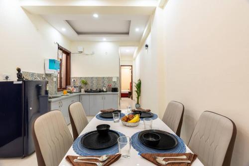 a dining room with a table and chairs and a kitchen at Homlee-Vasundhara 2BHK Flat with Kitchen parking in Ghaziabad