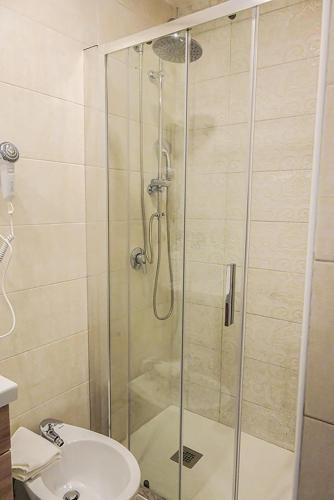 a shower with a glass door next to a toilet at Suisse hotel in Caserta