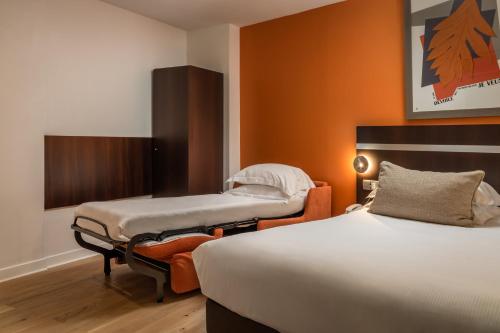 um quarto de hotel com duas camas e uma cadeira em Arc De Triomphe em Paris