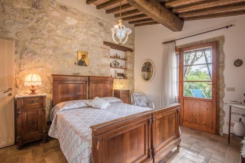ein Schlafzimmer mit einem Bett in einem Zimmer mit einer Steinmauer in der Unterkunft Appartamento Capannina in Lano