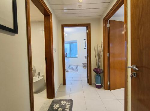 a hallway of a bathroom with a toilet and a tub at Trinity Holiday Homes - Sheikh Zayed Road Near to Financial Center Metro Station in Dubai